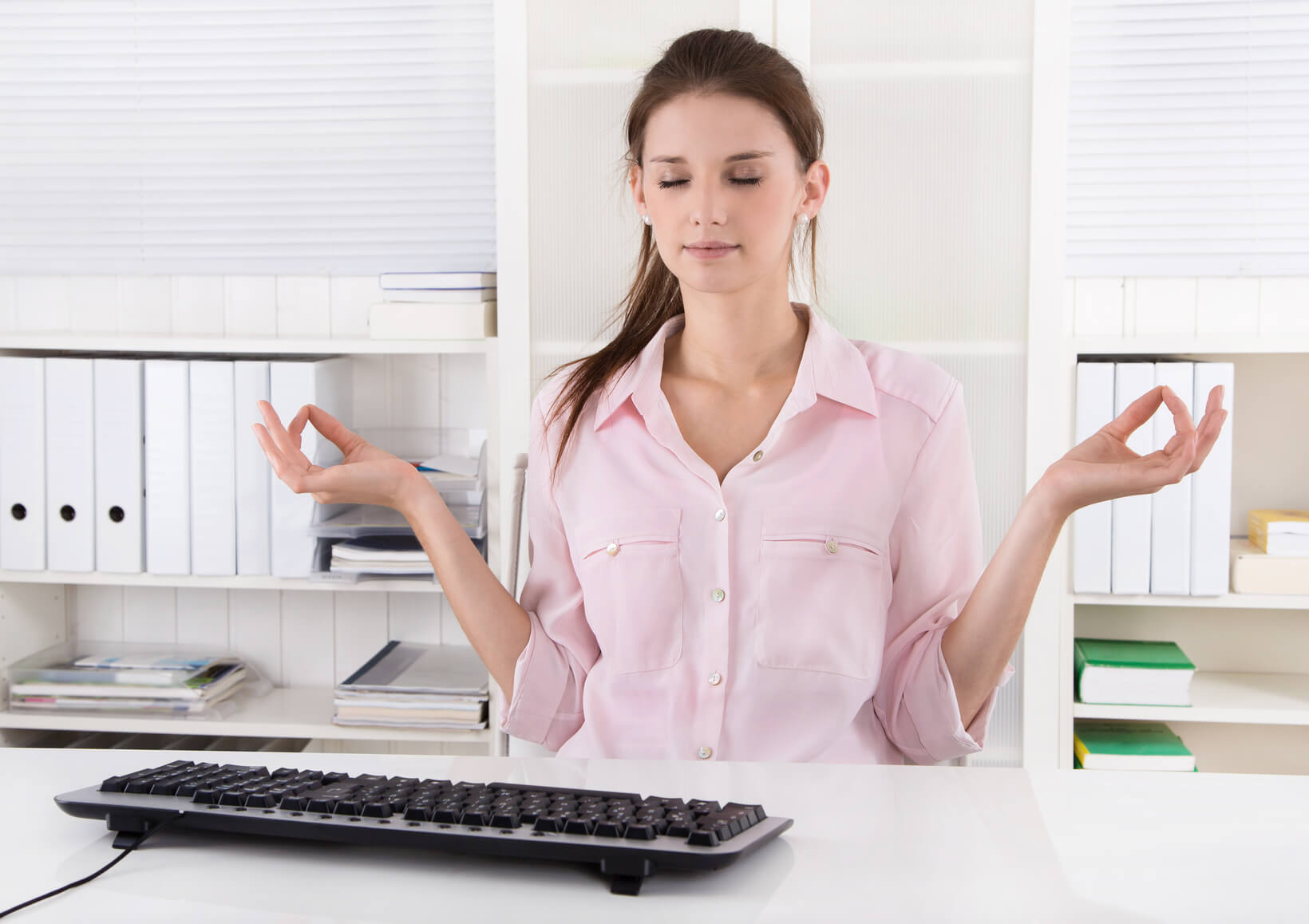 kobieta pozująca przy komputerze w biurze